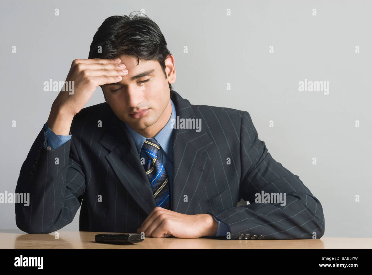 Businessman rubbing his forehead Stock Photo Alamy