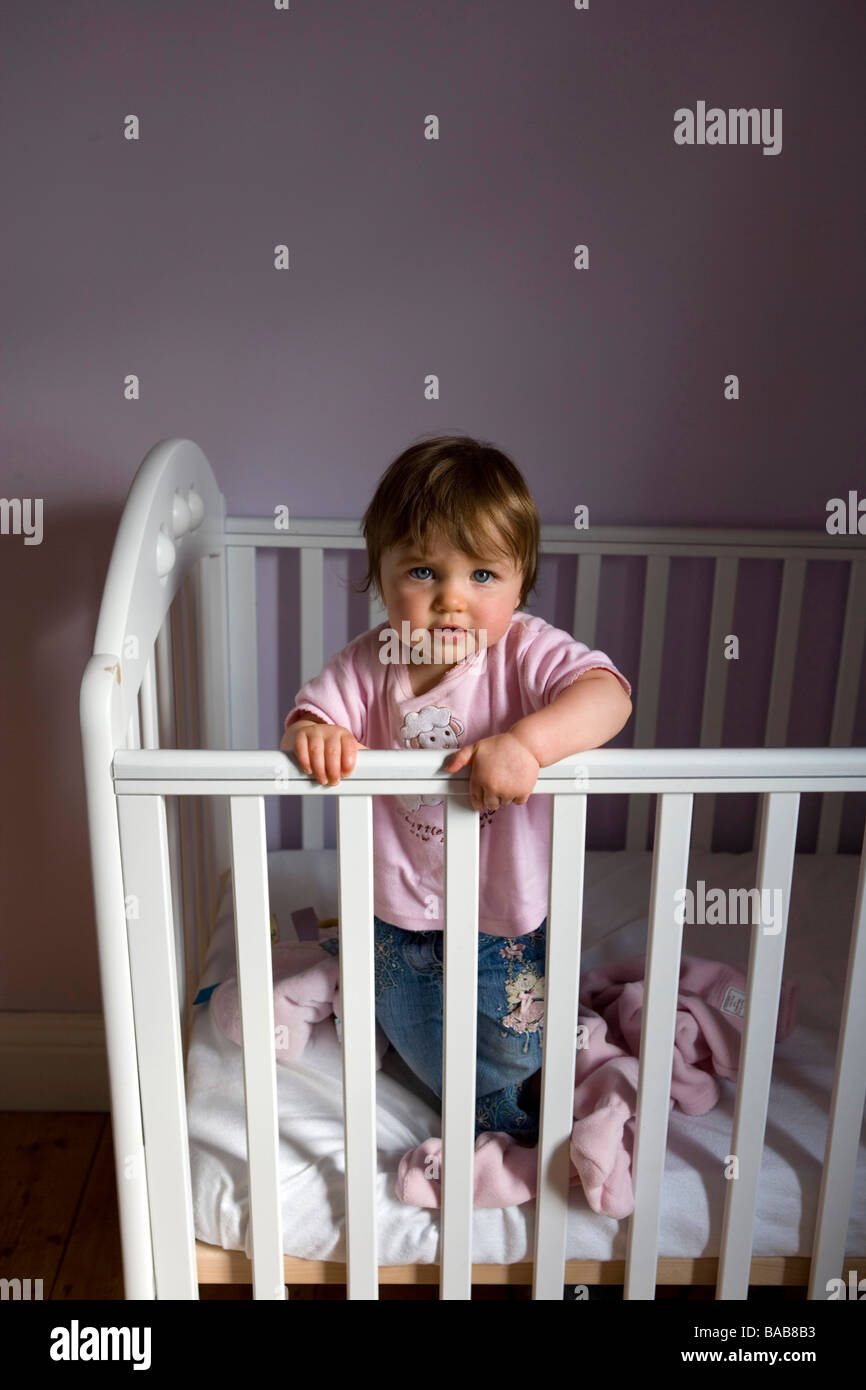 A one year old baby girl in her cot Stock Photo Alamy