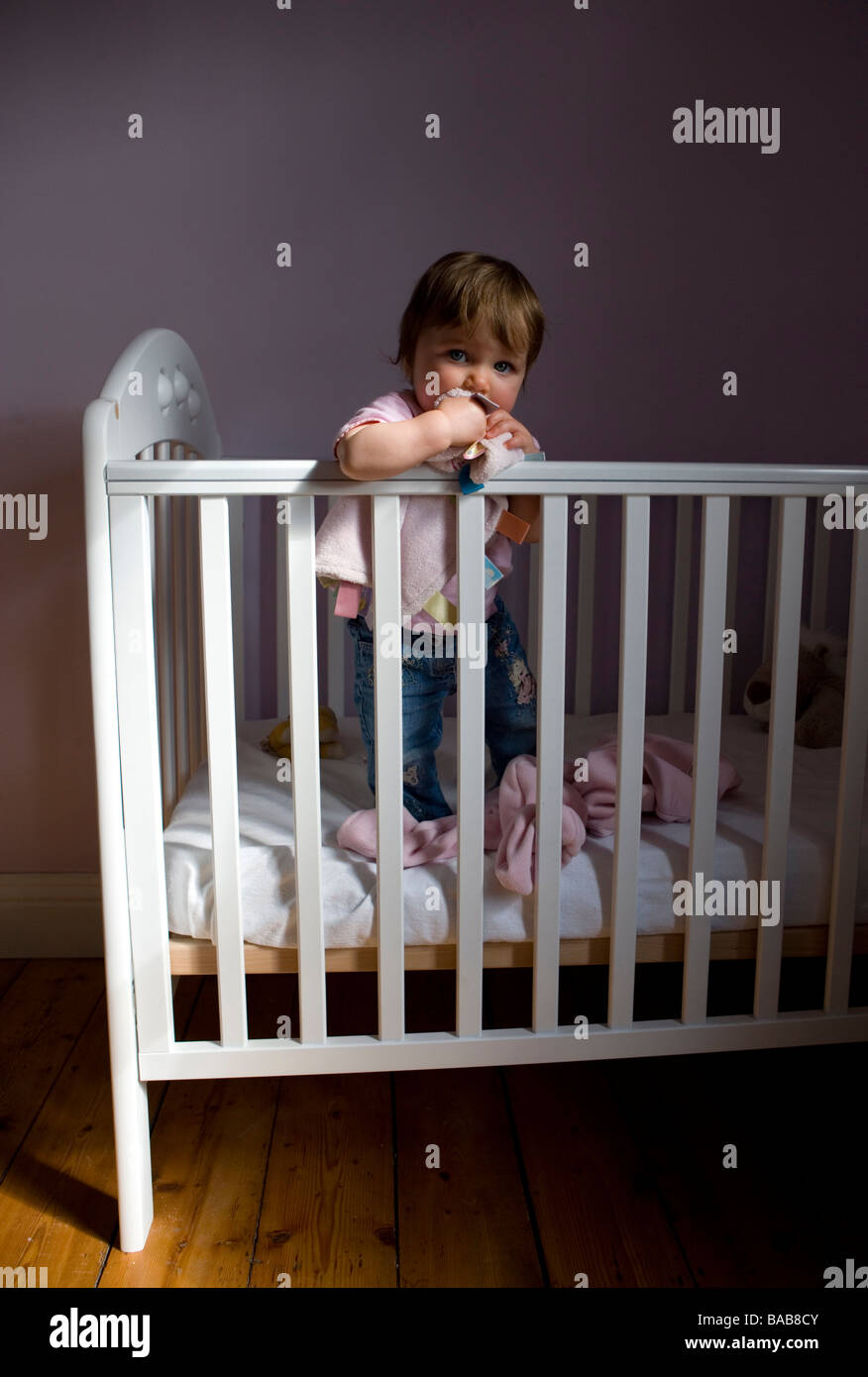 A one year old baby girl in her cot Stock Photo Alamy