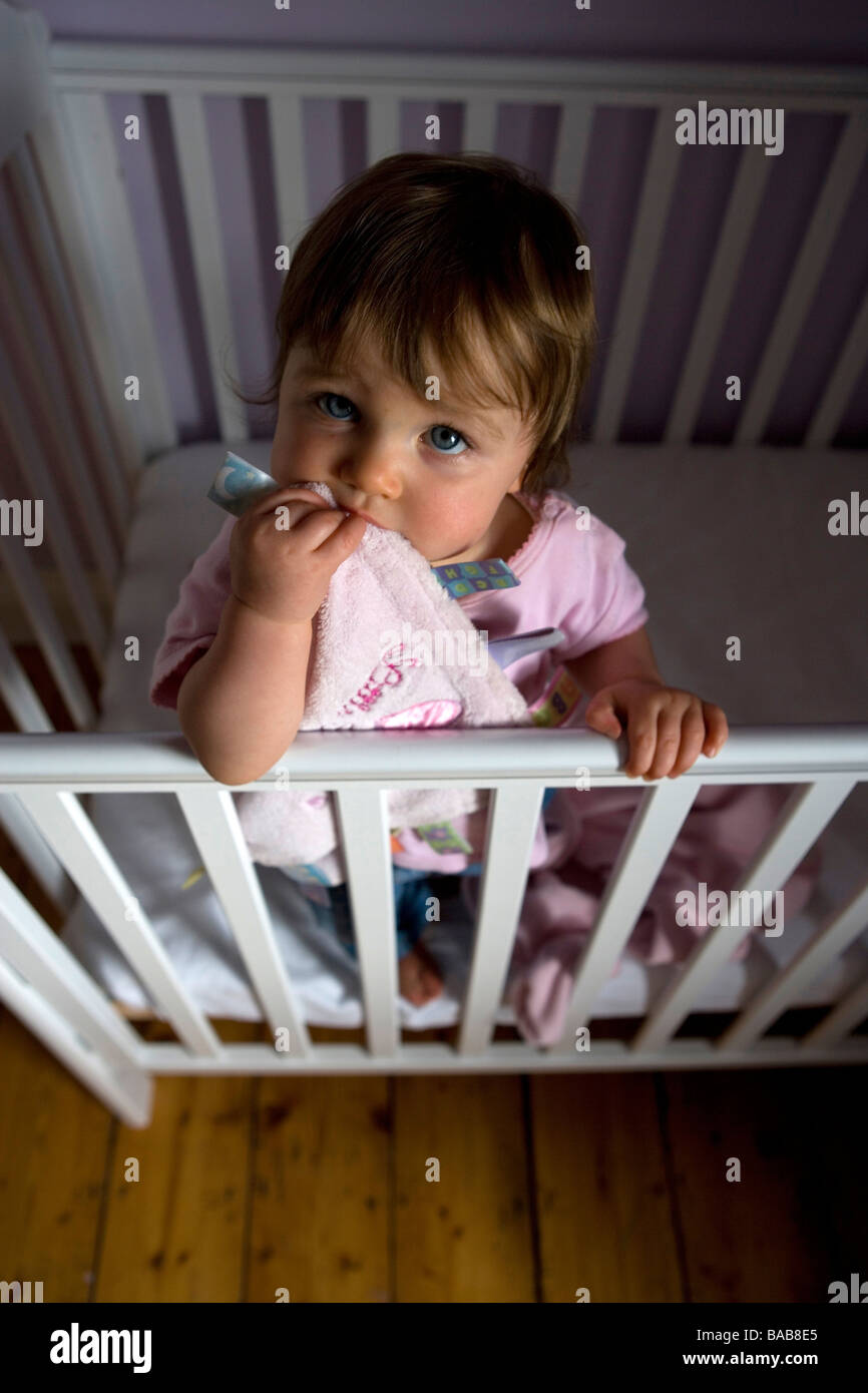A one year old baby girl in her cot Stock Photo Alamy