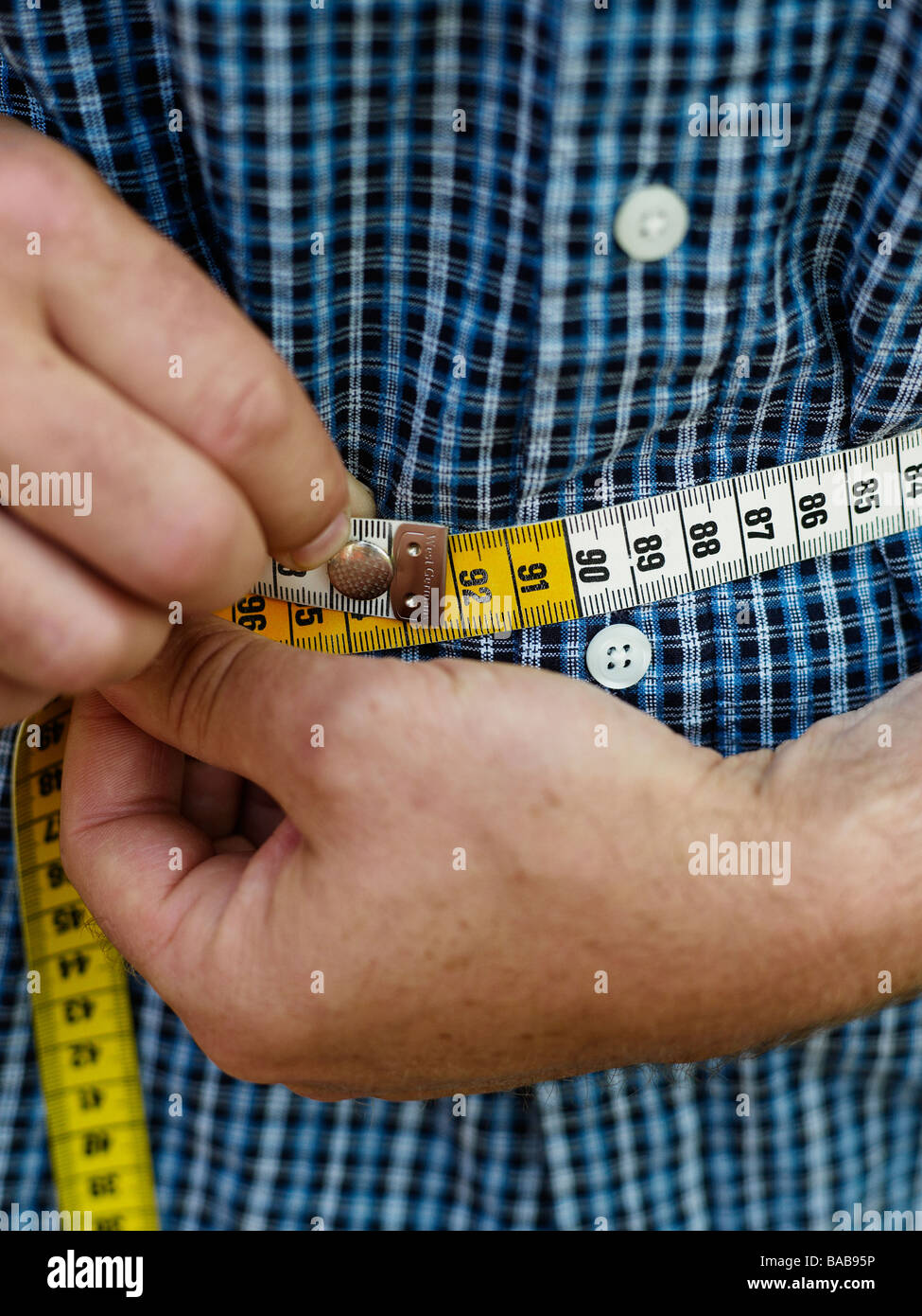 Man measuring his waist with a tape measure 2246454 Stock Photo at Vecteezy