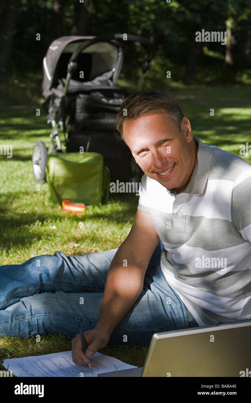 A man with a pram and a computer in a park a sunny day Sweden Stock ...