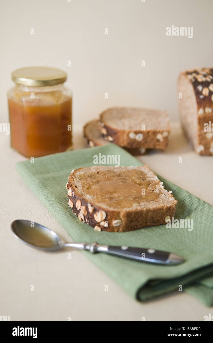 Raw Manuka honey spread on multigrain bread. Stock Photo