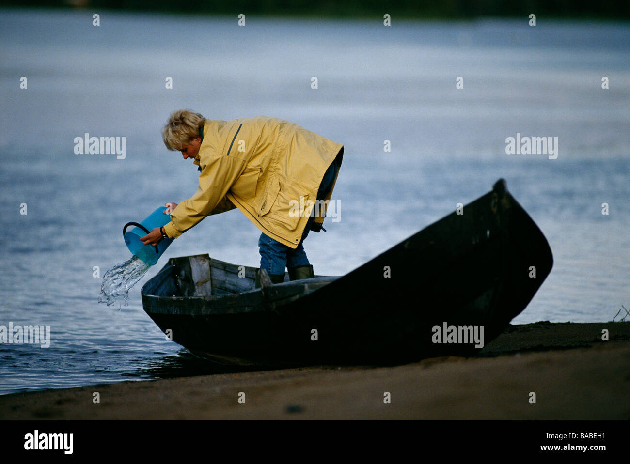 Woman bailing a boat Torne alv Sweden Stock Photo
