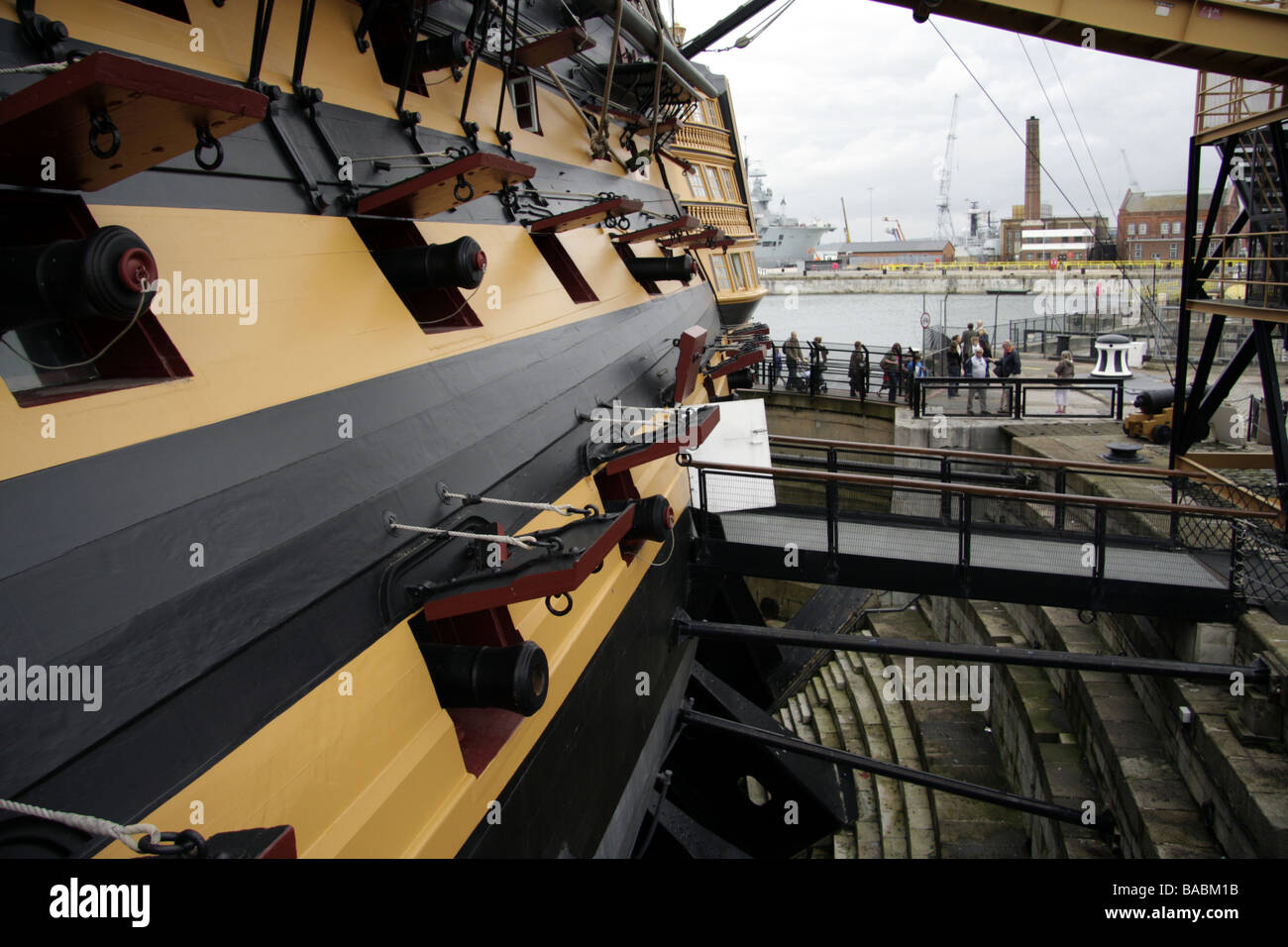 Gun ports on HMS Victory, showing unidentifiable visitors boarding the ship Stock Photo