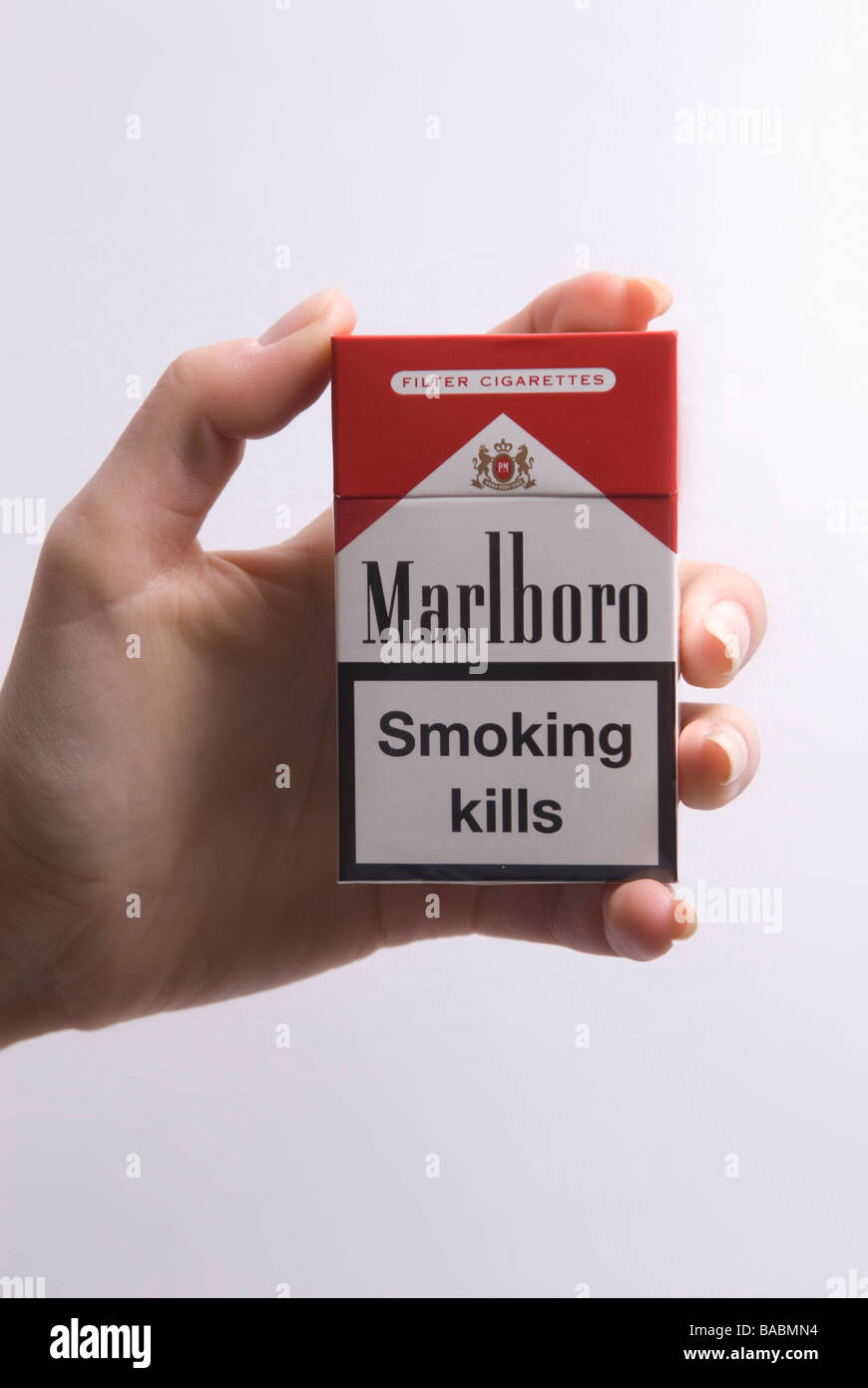 Woman's hand holding a pack of Marlboro red against a white background Stock Photo