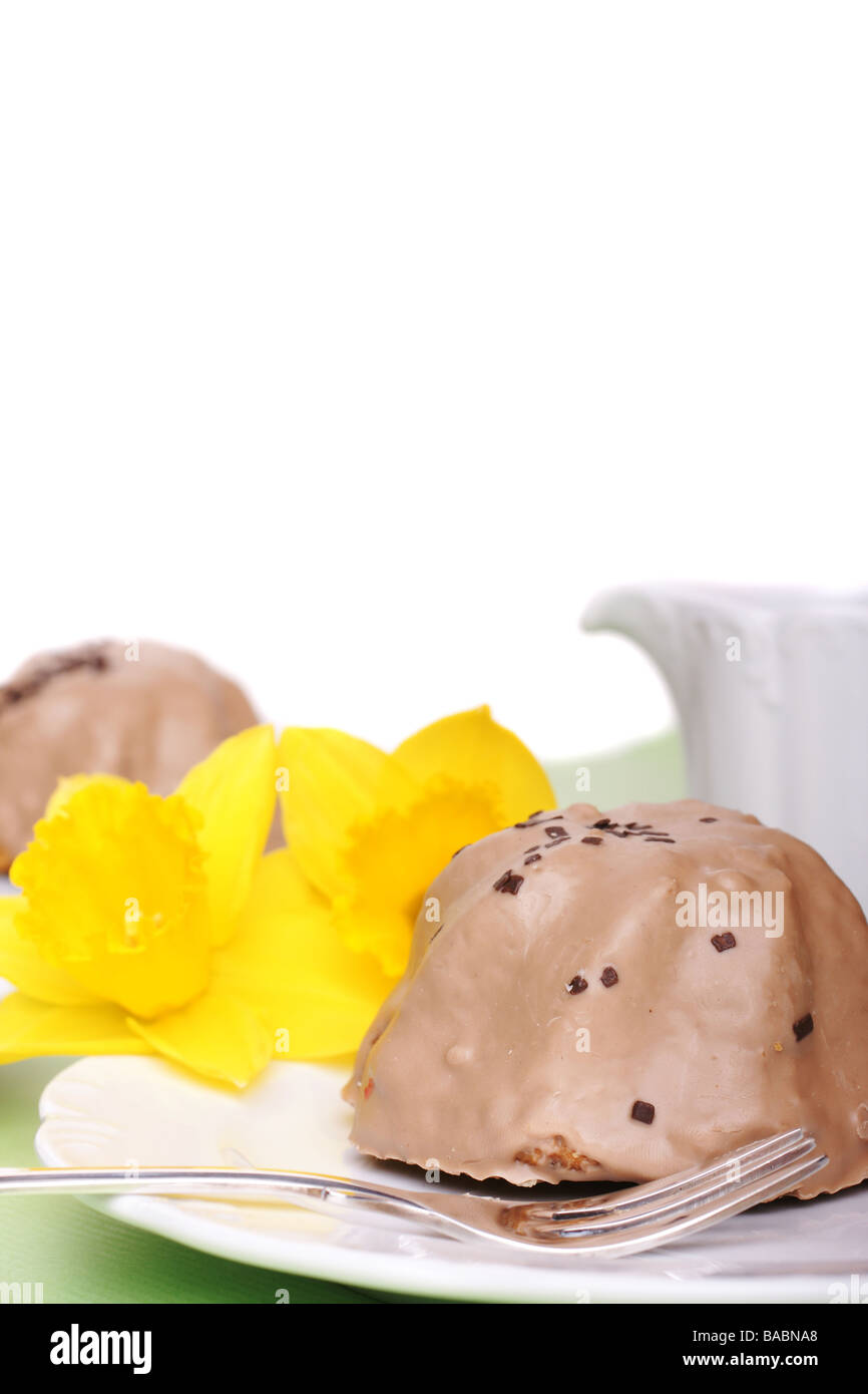Two little cupcakes with chocolate frosting and daffodils Stock Photo