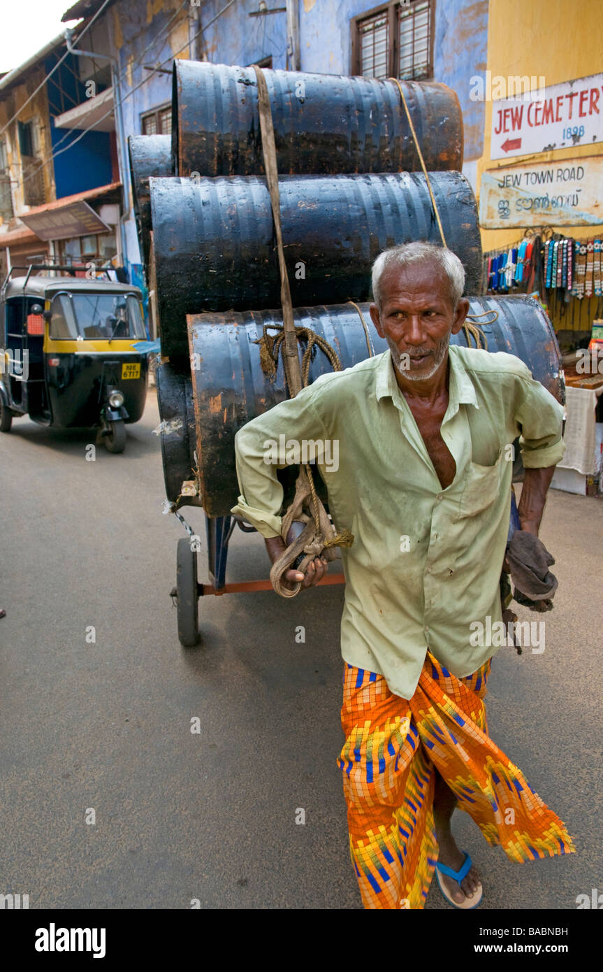 Street trader transporting drums of coconut oil from one depot to ...