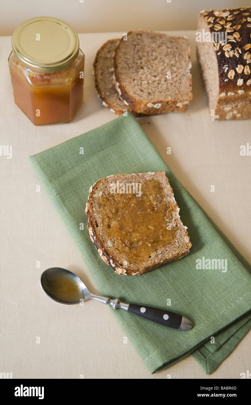 Raw Manuka honey spread on multigrain bread. Stock Photo