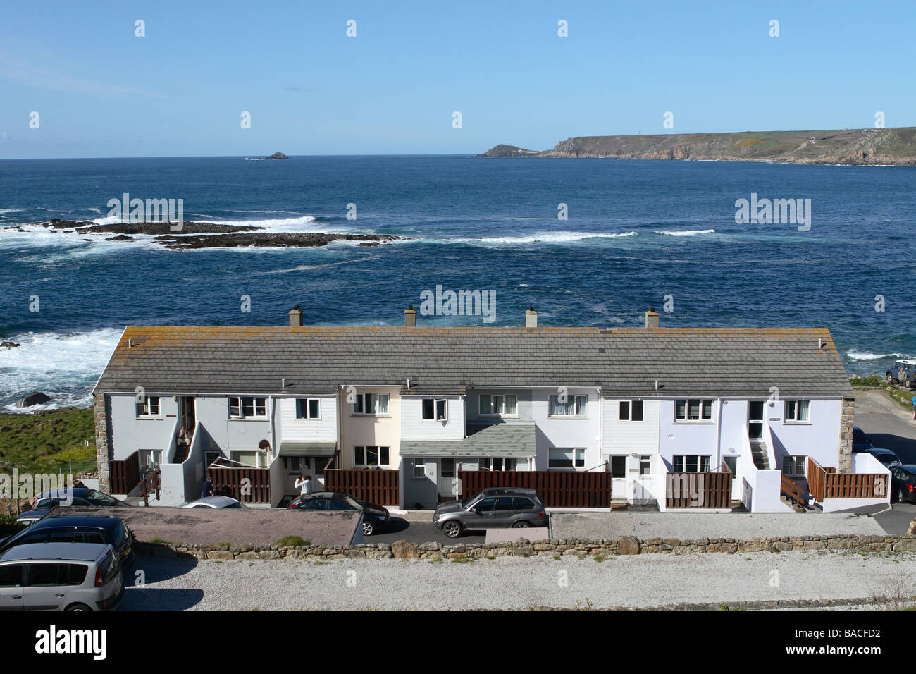 Sennen Cove village modern terraced housing and flats right on the Atlantic Coast coastal shoreline Stock Photo