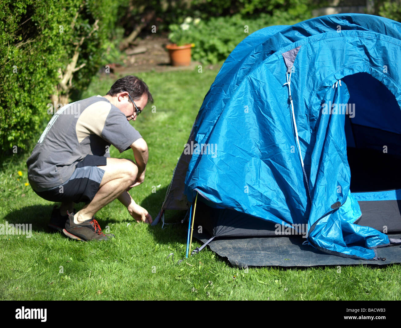 A camper setting up his tent Stock Photo - Alamy