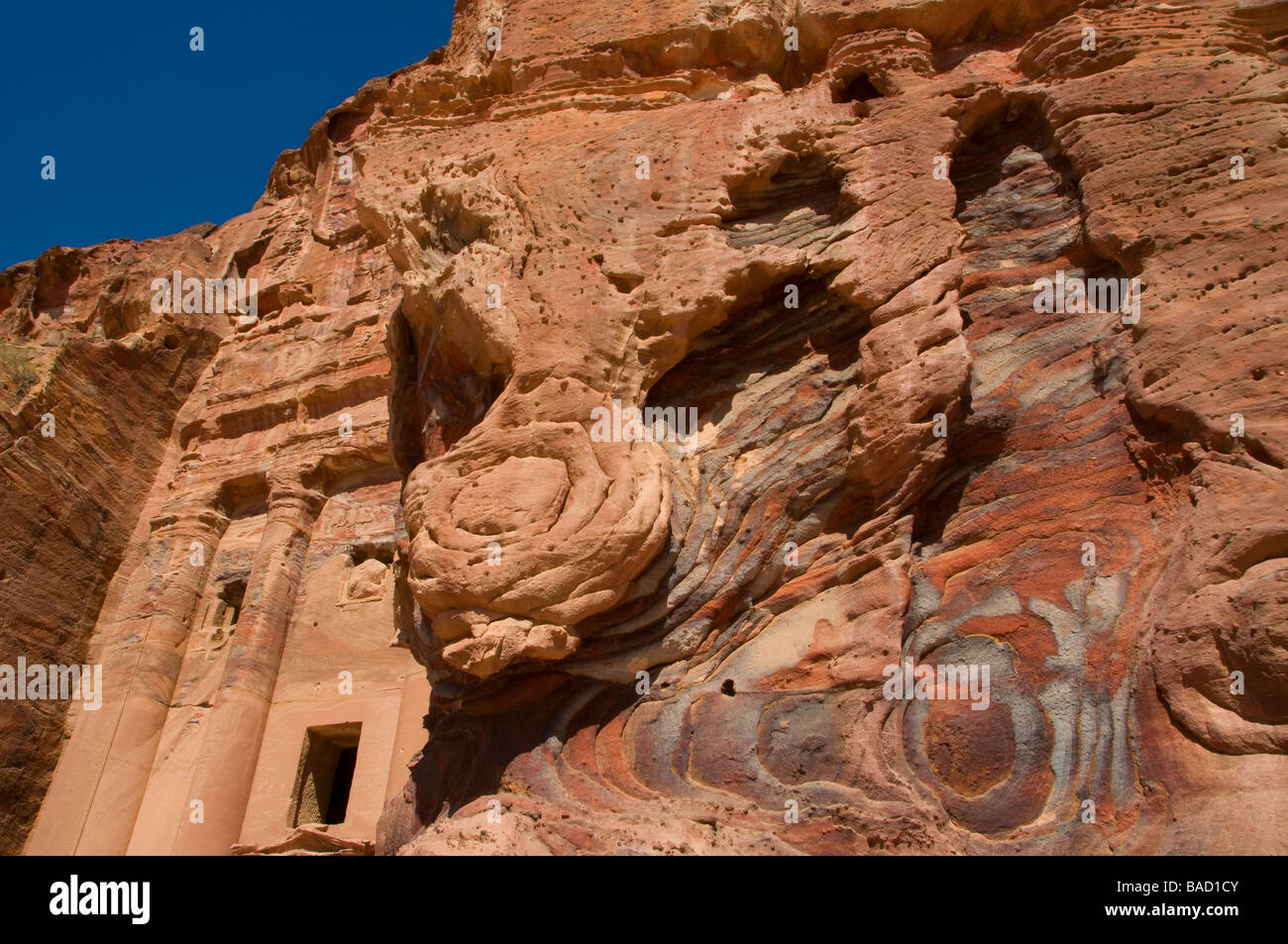 Cliff face of the ancient Nabatean rock cut monument named Urn Tomb carved into Jabal al-Khubtha at 'Royal Tombs' Petra Jordan Stock Photo