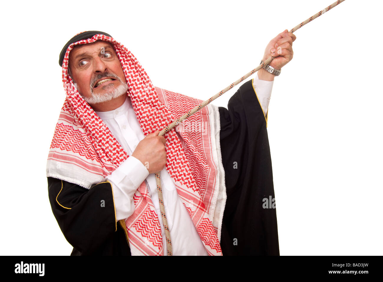 arab man trying to pull a camel along Stock Photo