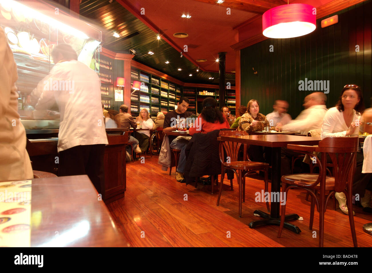 People eating in a Tapas Bar with busy waiters serving blurred Stock Photo