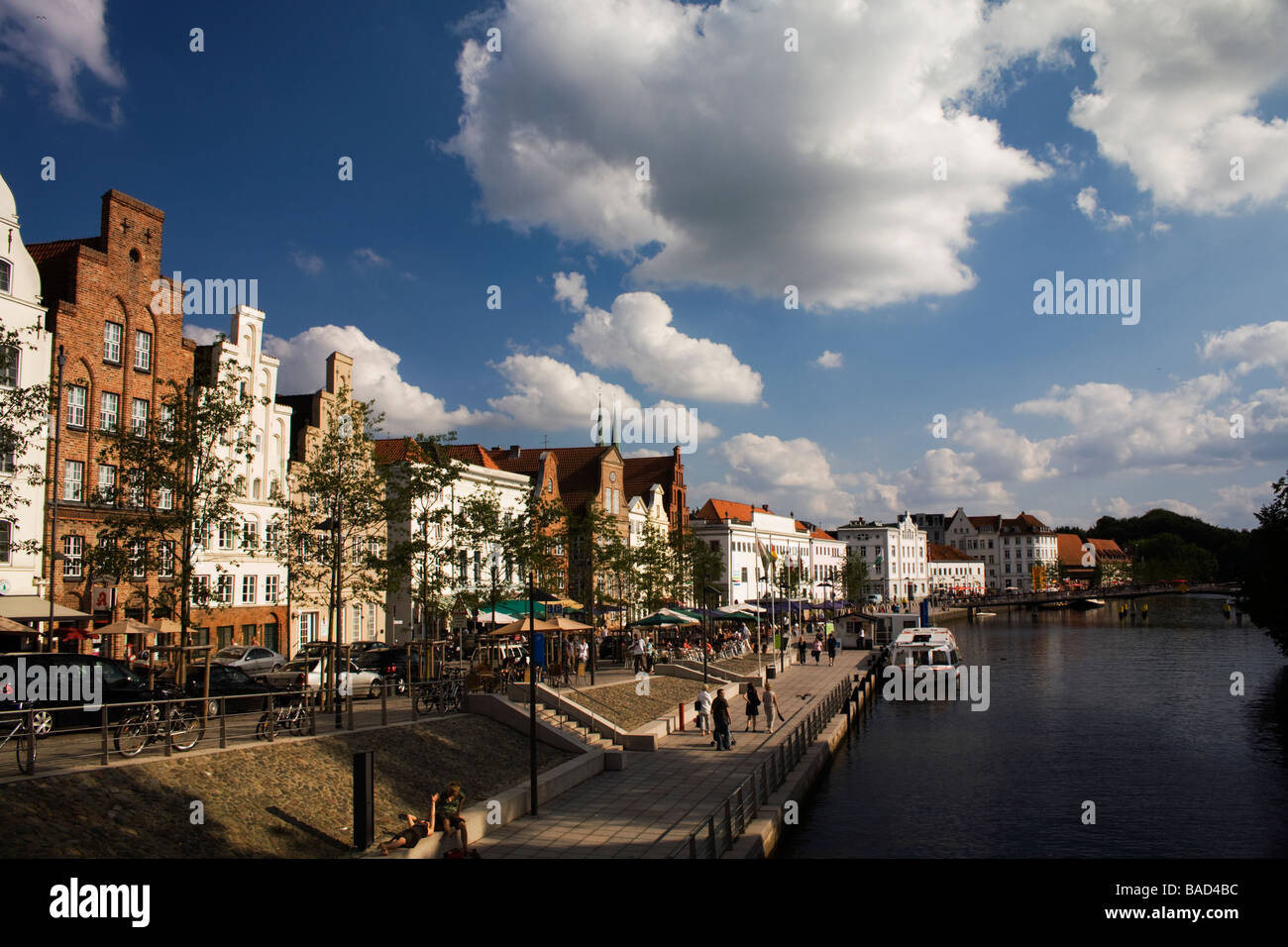 Luebeck, Schleswig- Holstein, Germany. Waterfront Crow-step gable houses and river Trave with tourists along its walkway Stock Photo