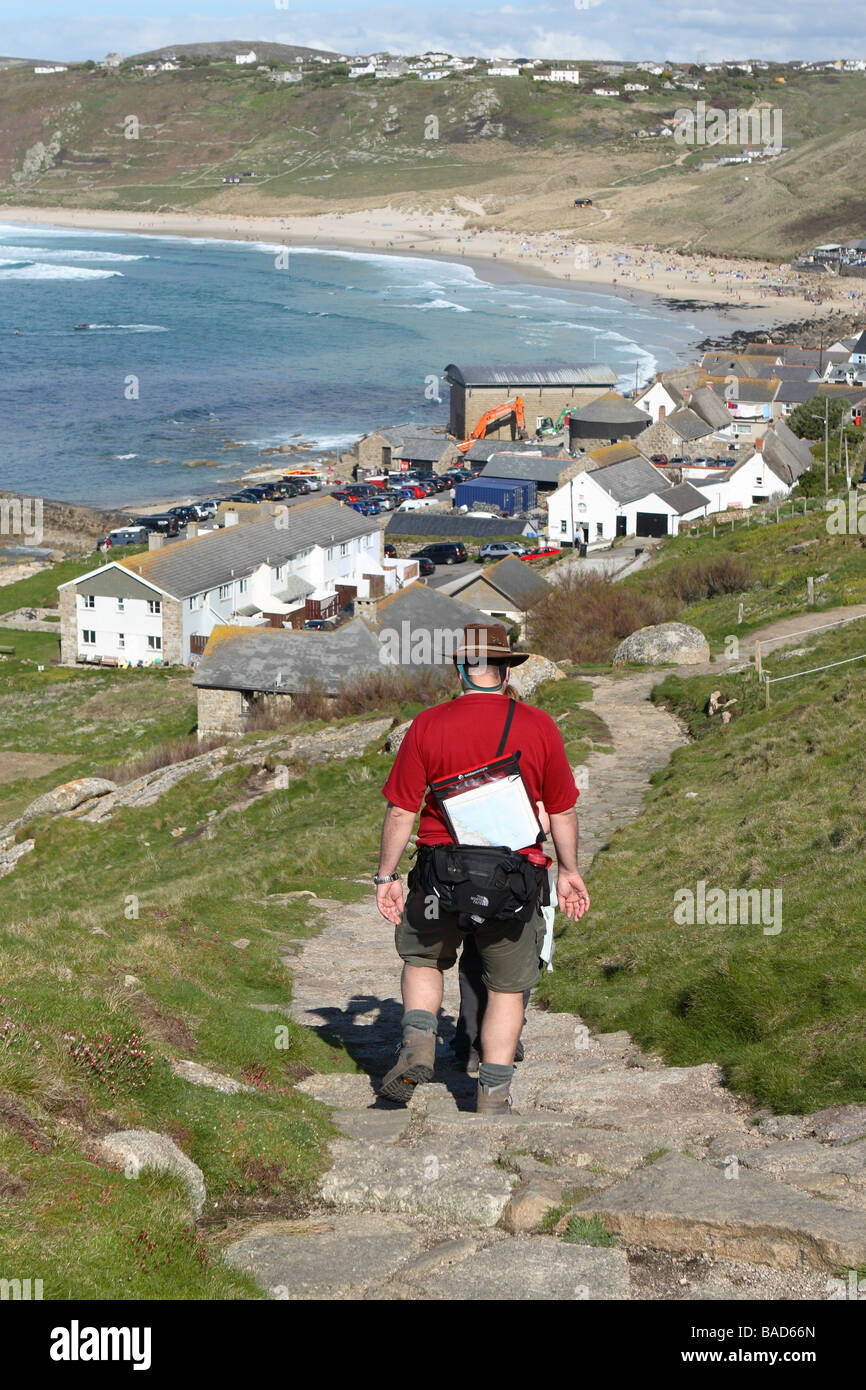 Sennen Cove village Cornwall walkers descend the South West Coast Path towards Sennen and Whitesands Bay Stock Photo