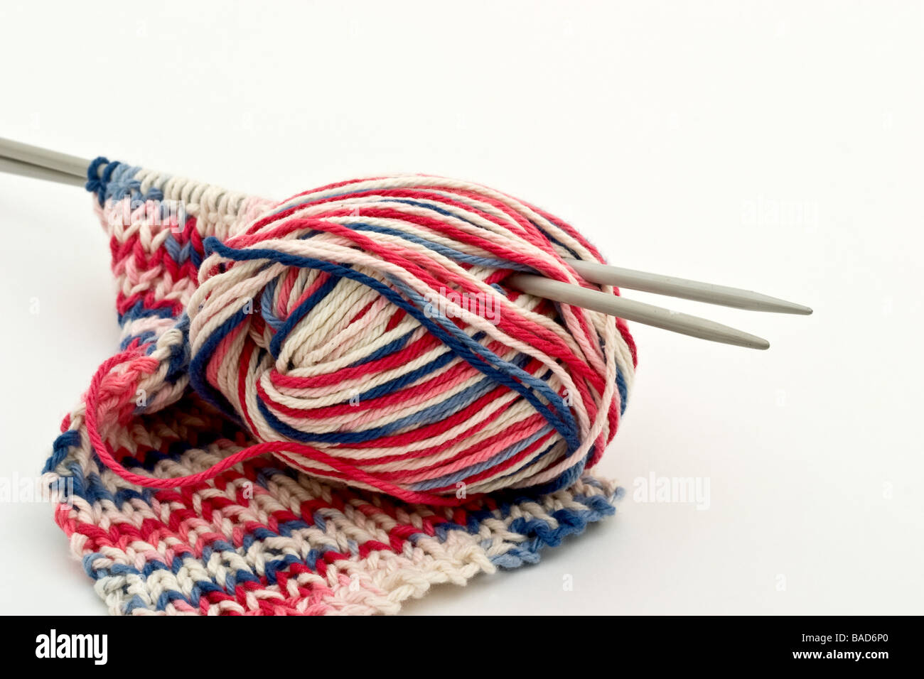 Two knitting needles in a ball of multicoloured yarn Stock Photo Alamy