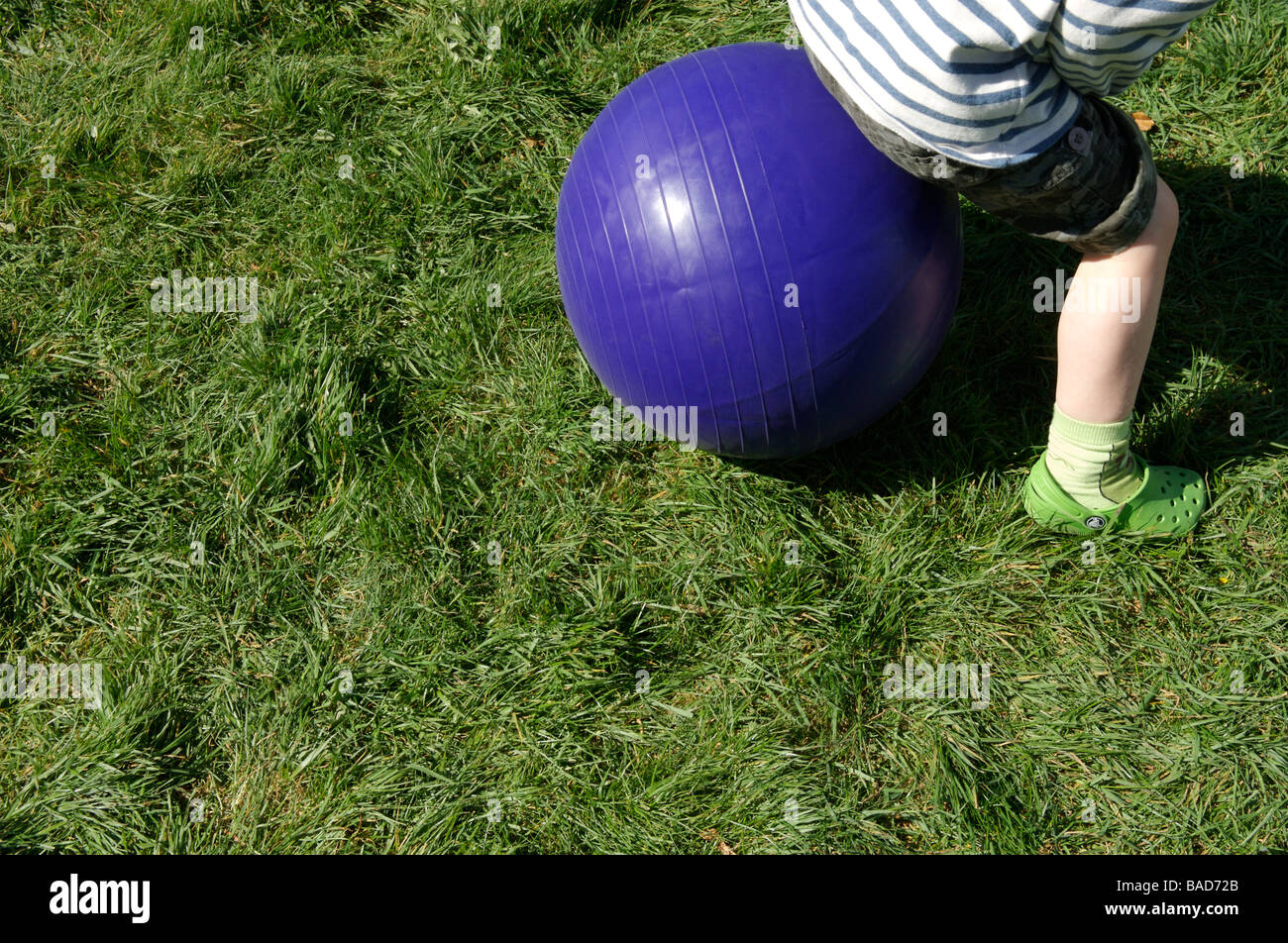 A young boy on a purple space hopper Stock Photo