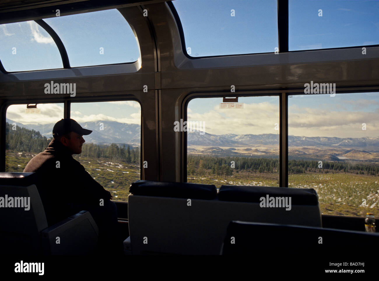 Train passenger looking out train car window at western landscape of