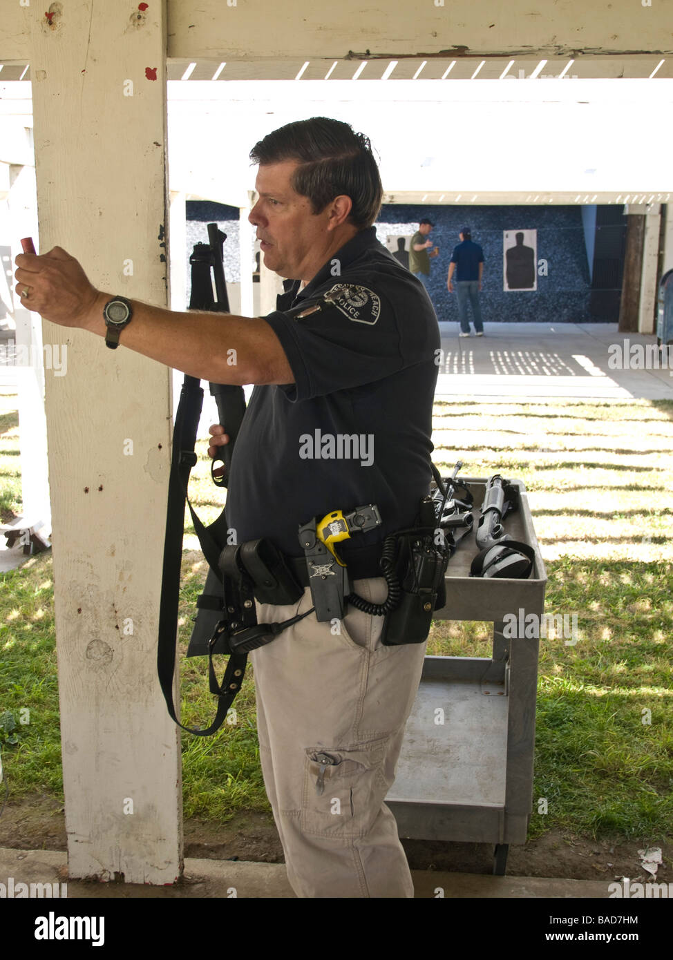 Range officer holds a 12 guage shotgun shell while demonstrating police