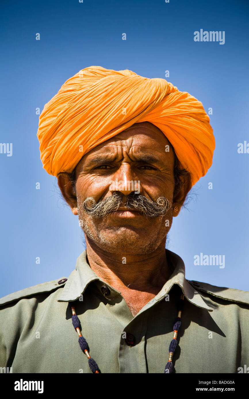 Man wearing a colourful saffron turban at Osian Camel Camp, Osian, Rajasthan, India Stock Photo