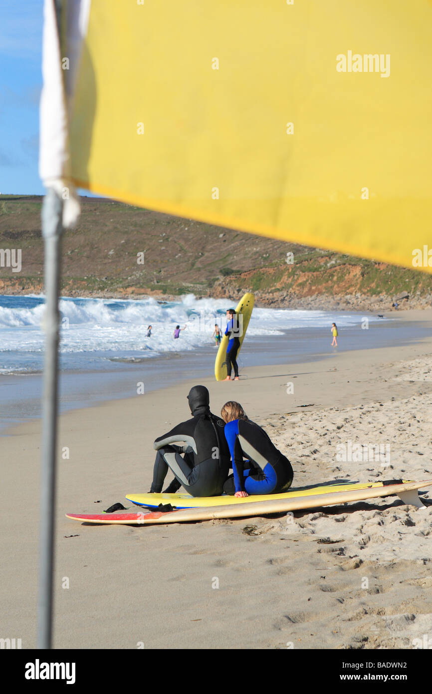 Sennen Cove beach Cornwall young surfing surfers relax on the sandy beach Stock Photo