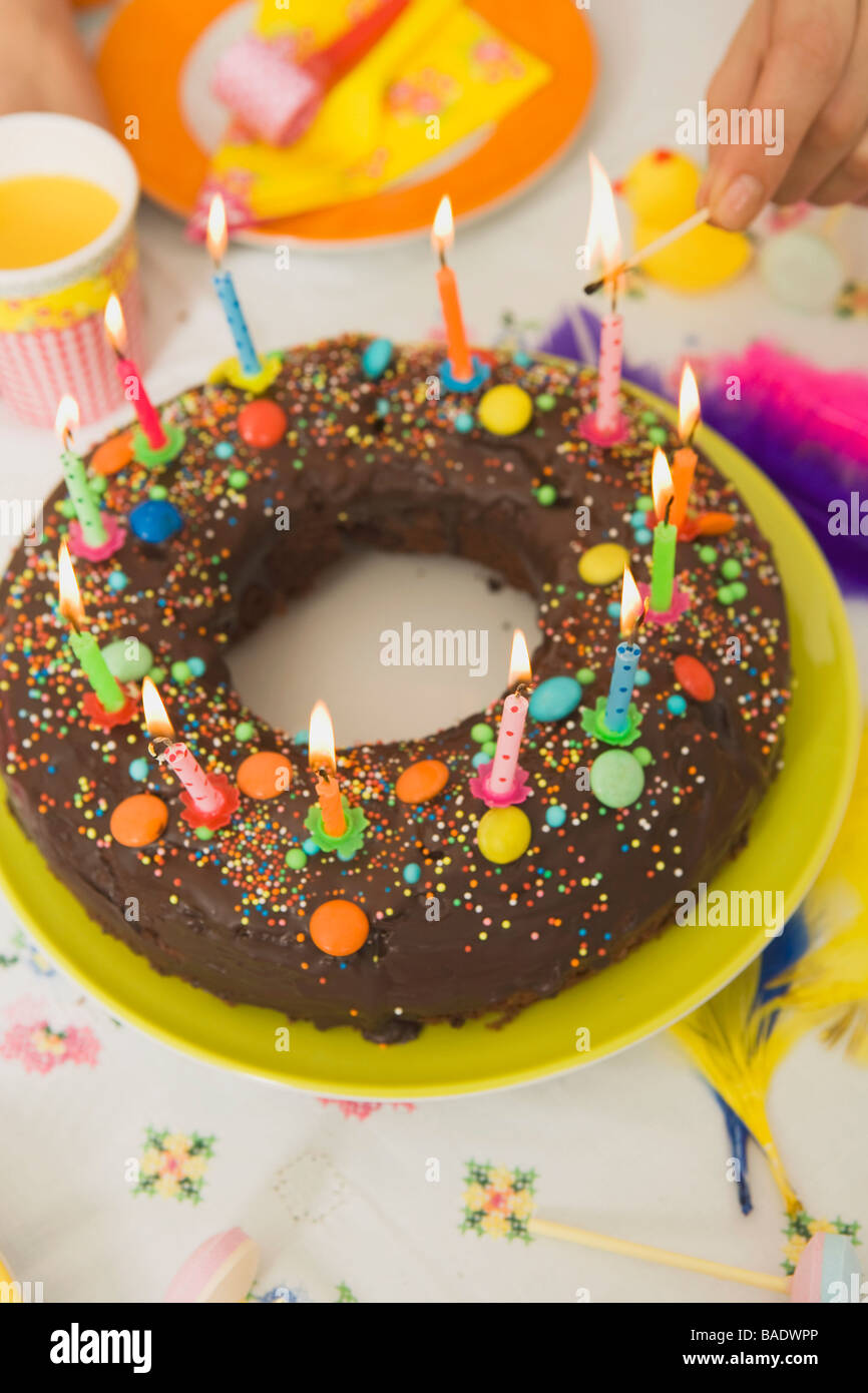 Woman Lighting Candles on Birthday Cake Stock Photo - Alamy