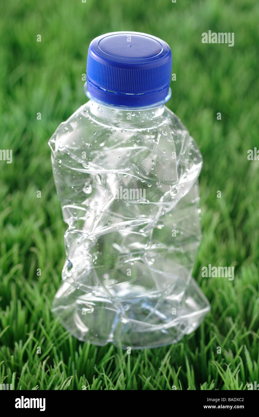 Crumpled Plastic Bottle in Grass Stock Photo