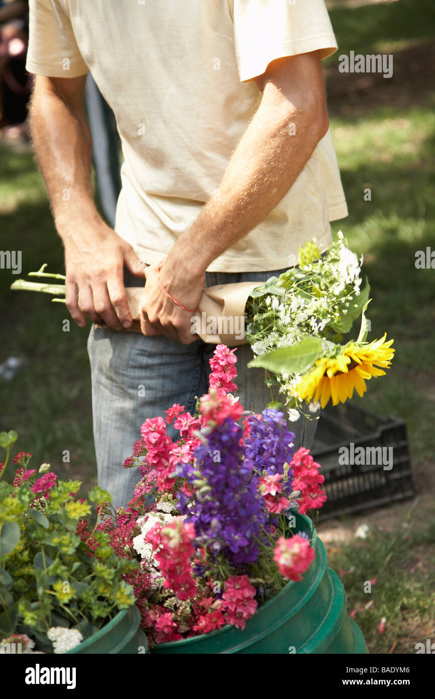 Flower Seller Wrapping Flowers at Organic Farmer's Market Stock Photo