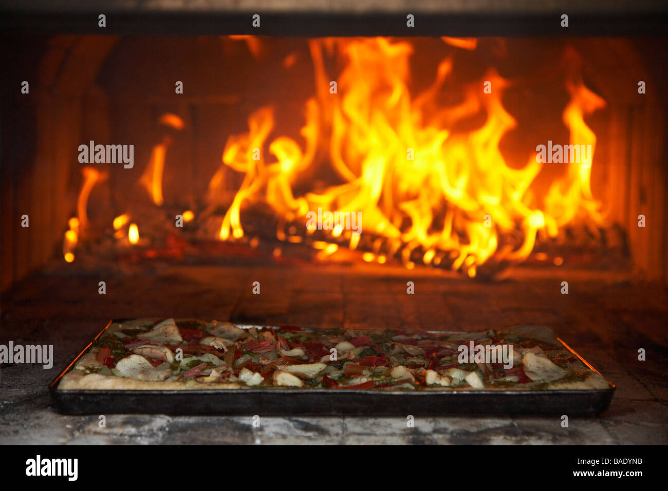 Pizza Cooking in Outdoor Pizza Oven Stock Photo