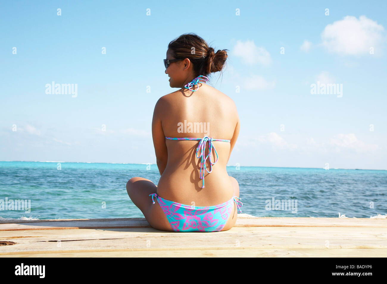 Woman Sitting on Dock, Belize Stock Photo