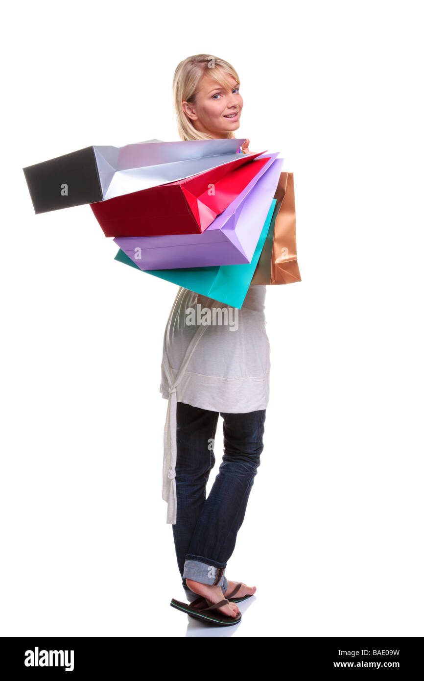 Beautiful young blonde woman carrying colourful shopping bags and looking back over her shoulder isolated on white background Stock Photo