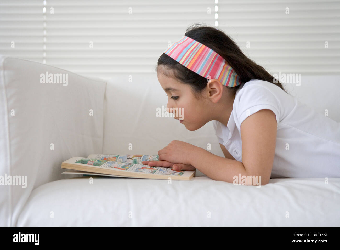 Little girl is reading a comic book Stock Photo