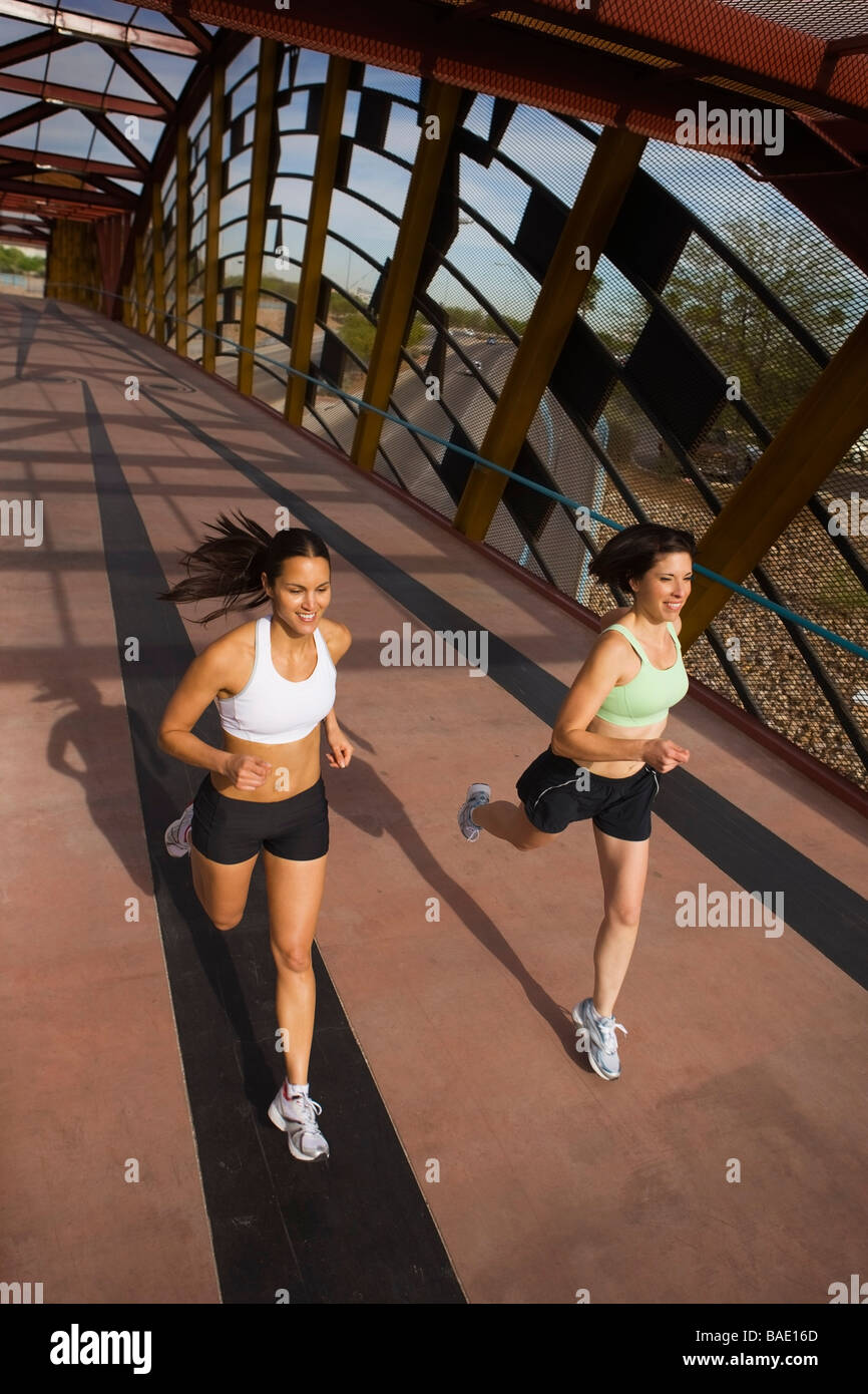 Two Women Running Across a Pedestrian Bridge, Tucson, Arizona, USA Stock Photo