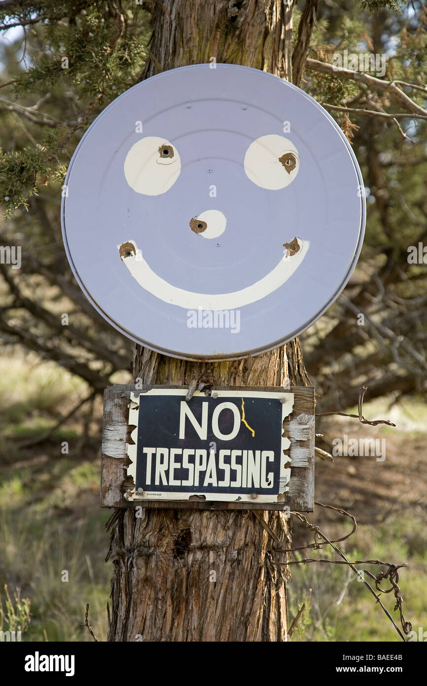 USA OREGON CROOKED RIVER VALLEY A No Trespassing sign and a smiley face with bullet holes Stock Photo