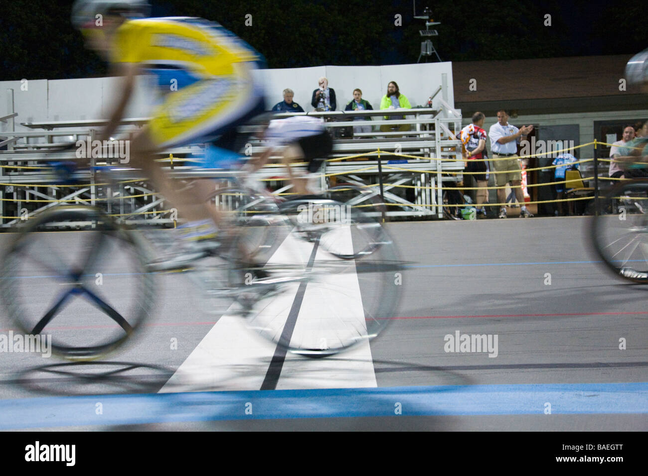 ILLINOIS Northbrook Bicyclists cross lap line during bicycle race at velodrome track spectators in stands video camera record Stock Photo