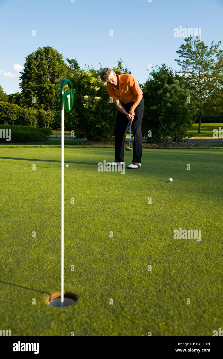 GOLF Adult middle aged male practice putting on green at public course in Deerfield Illinois swing putter Stock Photo