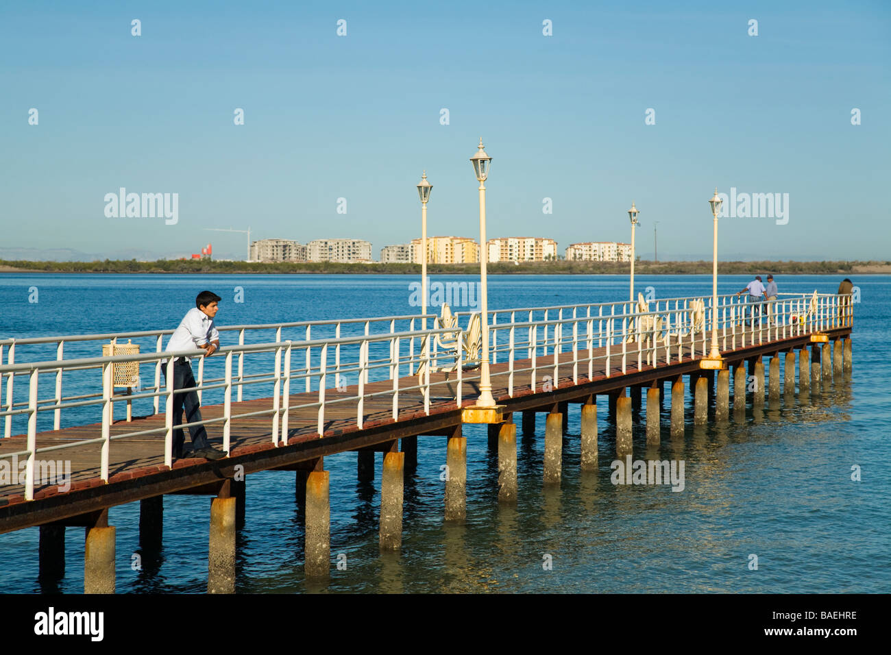 MEXICO La Paz Young man lean on metal railing on Queens Pier which Queen Elizabeth used when visiting city source of pearl Stock Photo