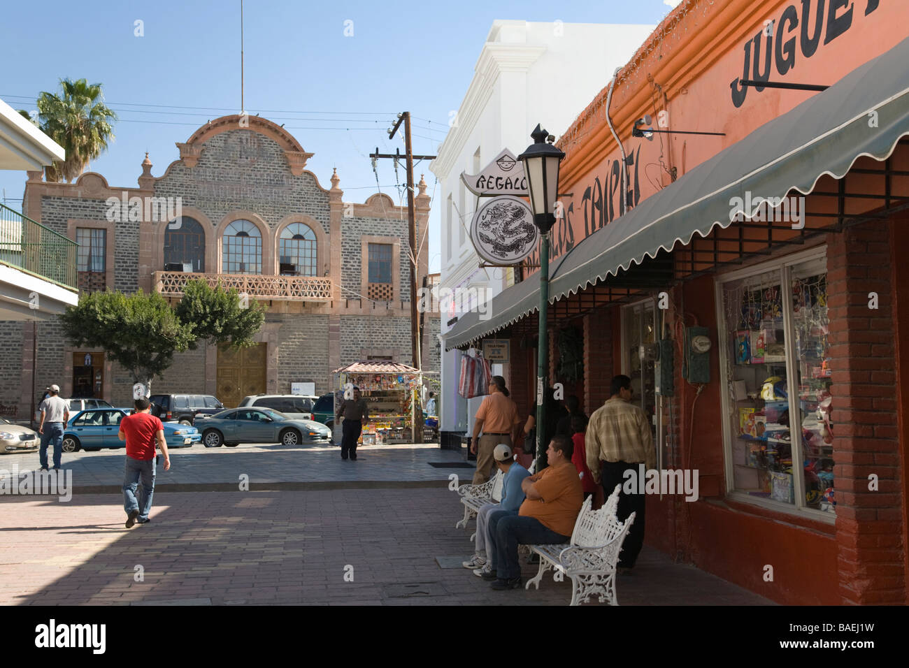 MEXICO La Paz Pedestrian mall with people sitting on benches outside retail stores downtown business district Stock Photo