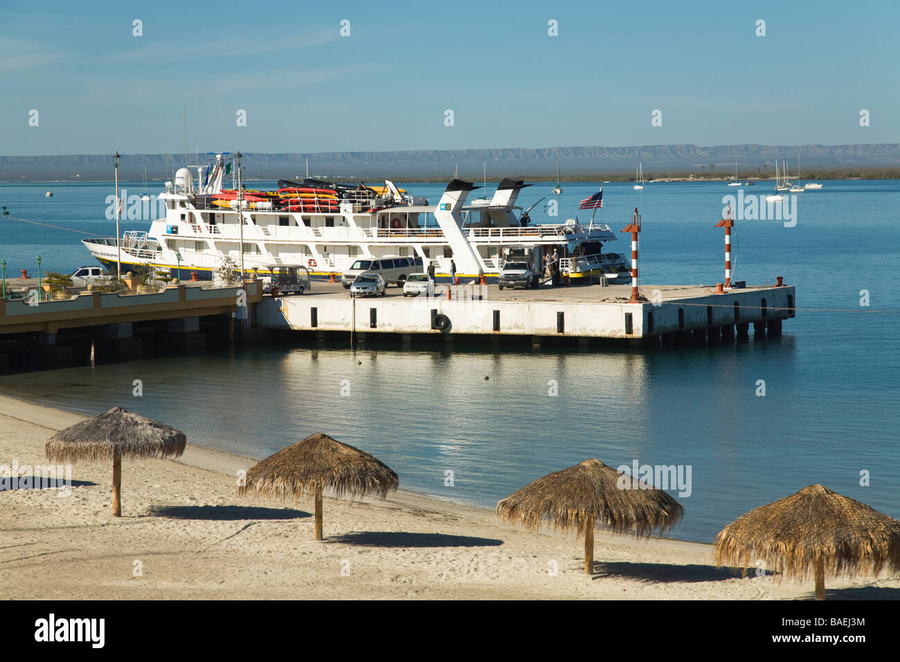 MEXICO La Paz Ferry boat docked at pier Tourist Dock palapa umbrellas along beach Stock Photo