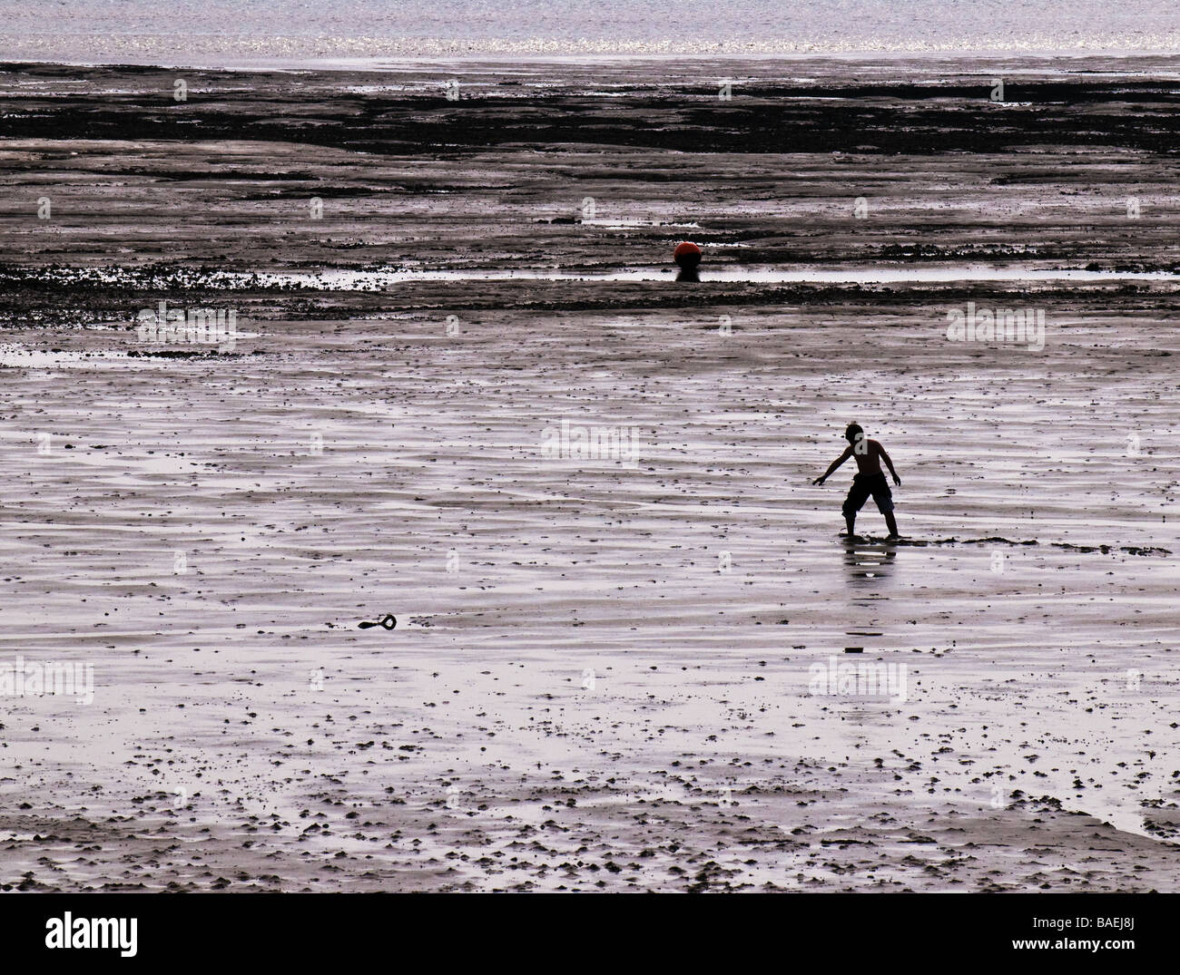 Person struggling to walk across the mud at lowtide at Southend on Sea in Essex.  Photo by Gordon Scammell Stock Photo