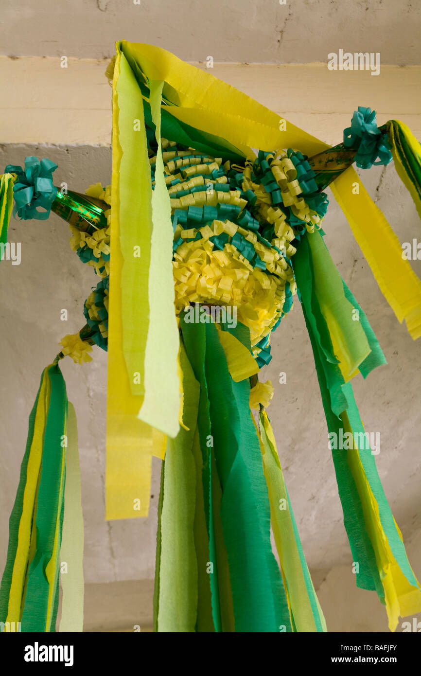 MEXICO Todos Santos Pinata with colorful yellow and green streamers hanging from ceiling Stock Photo