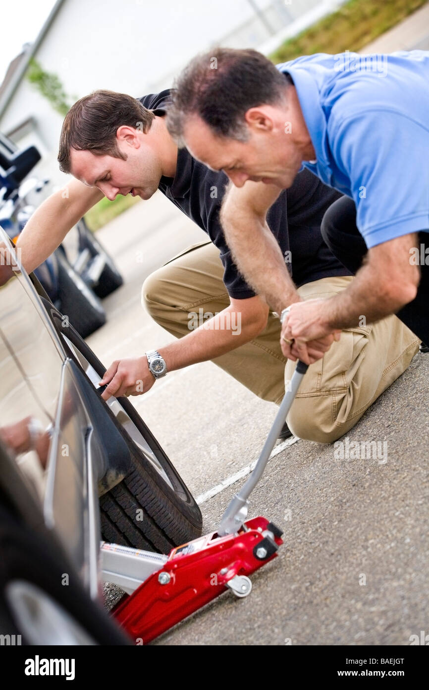 Two men fixing a flat tire Stock Photo