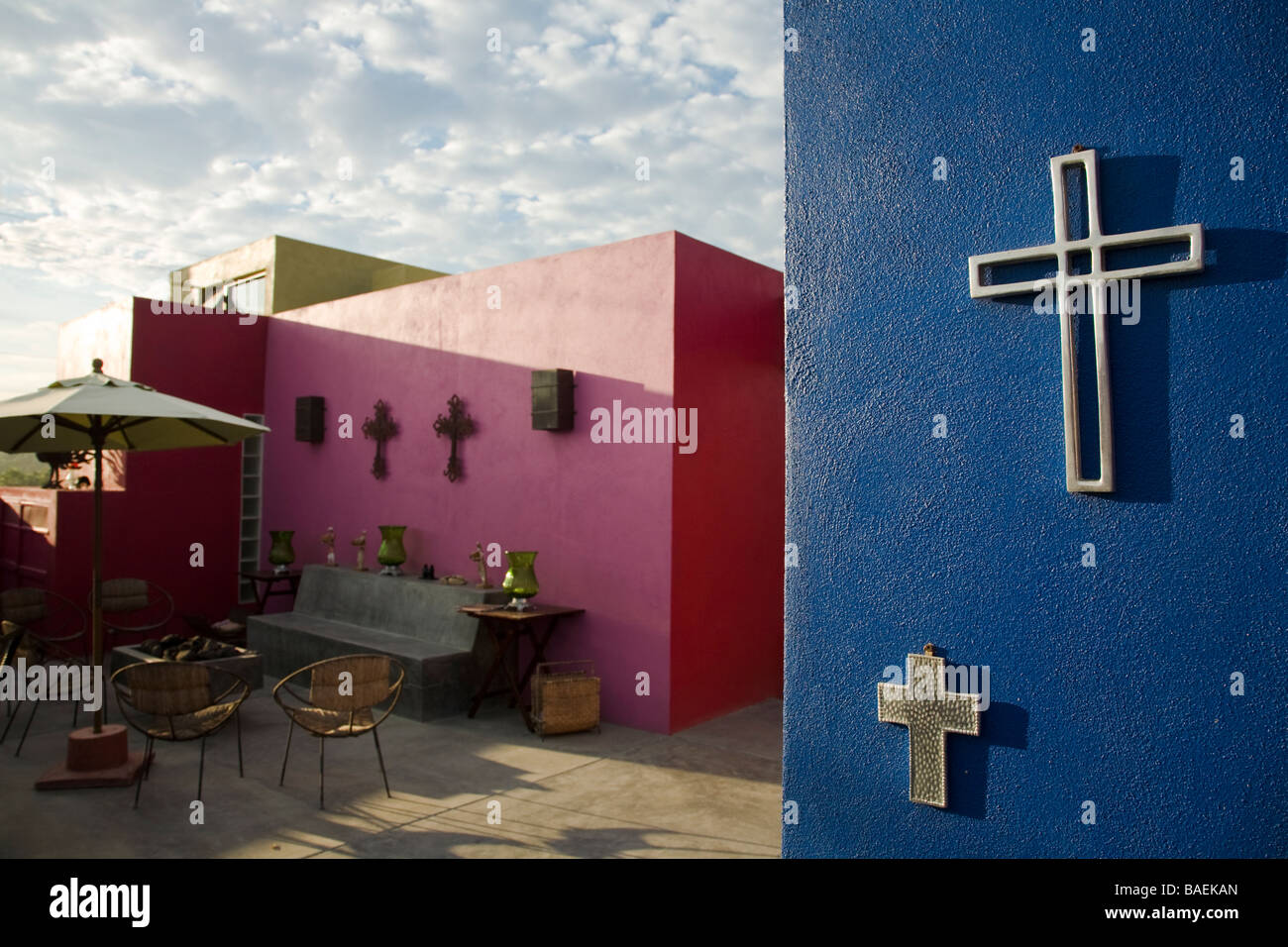 MEXICO Todos Santos Silver Mexican cross hanging on blue wall outdoors in decorative display at El Hotelito boutique hotel Stock Photo