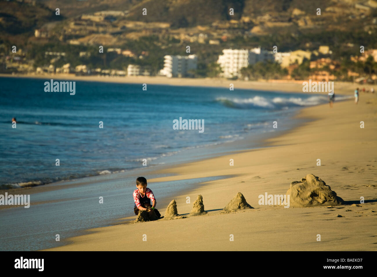 MEXICO San Jose del Cabo Young boy building sand castles on beach in early morning resorts along waterfront Stock Photo