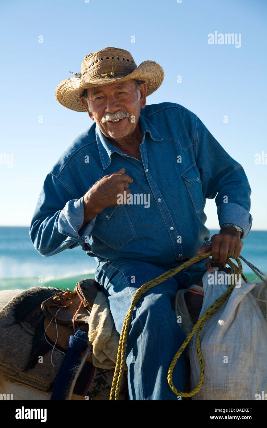 MEXICO San Jose del Cabo Portrait of Mexican man on horseback wearing cowboy hat and riding horse on beach Stock Photo