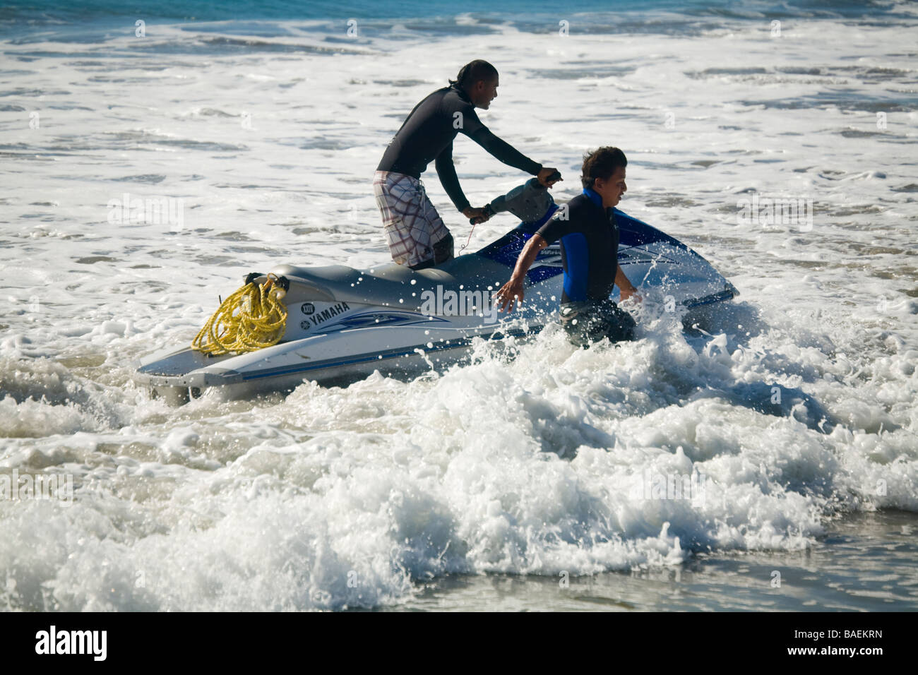 MEXICO San Jose del Cabo Man riding jet ski in shallow water near beach and man running in waves Stock Photo