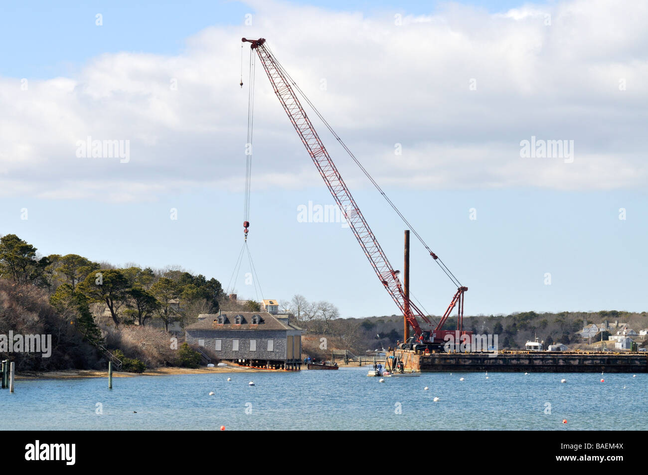 Crane on a barge preparing to lift and move a boat house in 'Stage Harbor' Chatham 'Cape Cod' Stock Photo