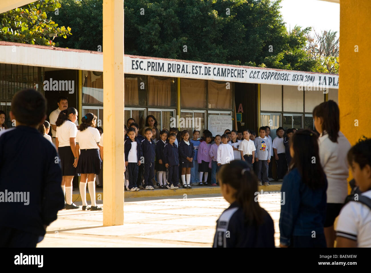 MEXICO La Playita Elementary school children wearing school uniforms recite opening exercises in school courtyard Stock Photo