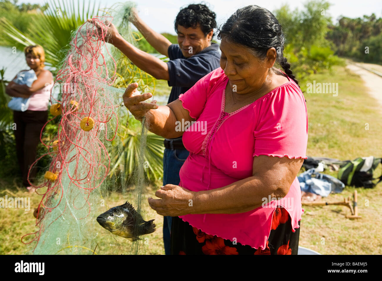 MEXICO San Jose del Cabo Mexican man and woman holding net with fish fishing in freshwater river that feeds estuary Stock Photo